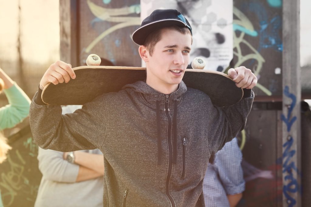 teen boy holding skateboard
