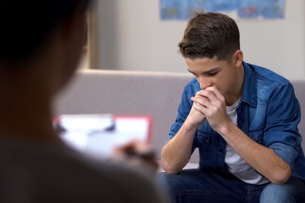 male teenager talking to therapist about 3 cbt techniques for teen anxiety