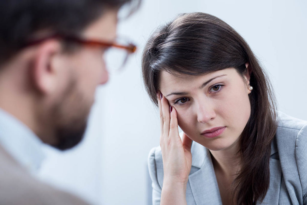 male therapist explains how does childhood trauma influence adulthood to troubled looking woman