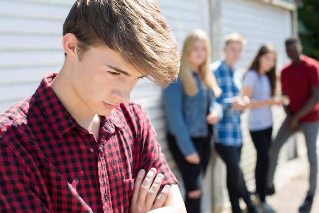 a teen is socially isolated and bullied by other teens at school