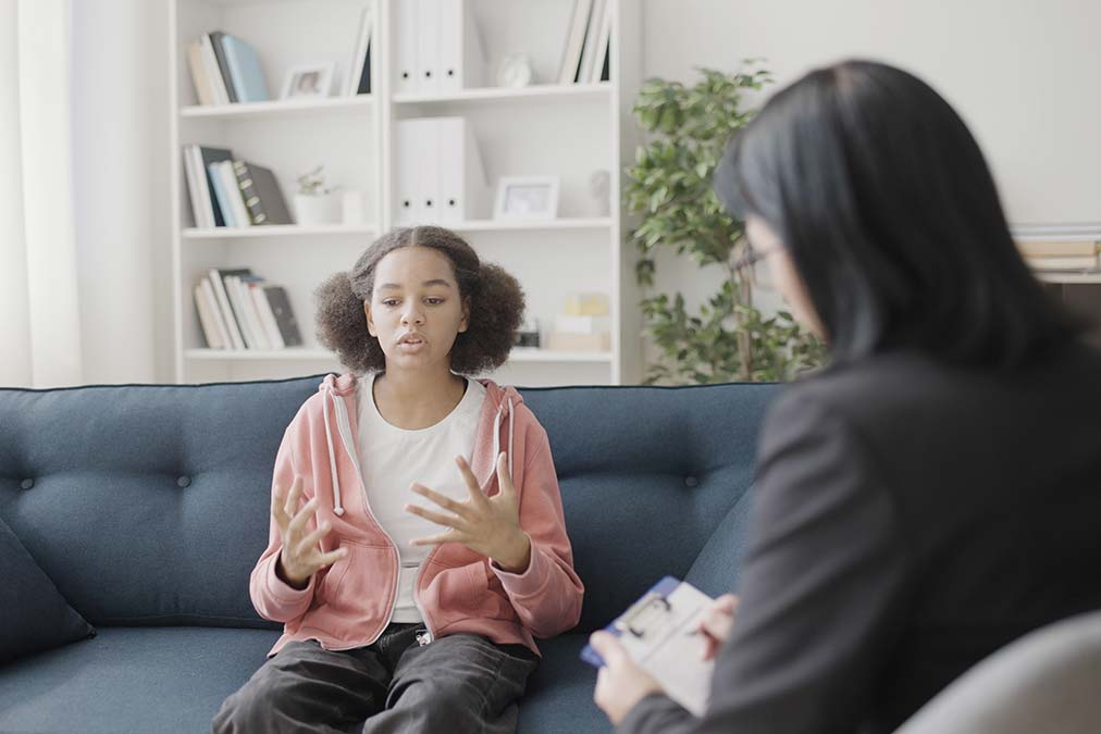 female therapist explaining 15 effective therapy activities for teens to a teenage patient
