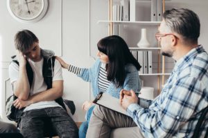 female group member consoling teenage male group member about the effects of stress on the teenage brain