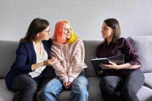 a family psychologist helps a mother and daughter reconnect in a family therapy program