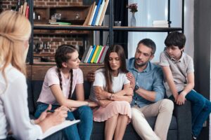 parents and teenagers meeting with therapist to receive a parents guide to succeeding in family therapy