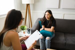 teenage girl having serious conversation with female therapist about the benefits of teen relationship counseling