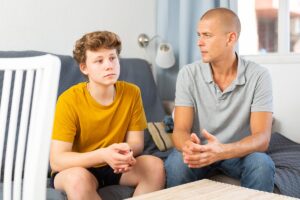 therapist explaining to father and his adolescent son the benefits of cognitive-behavioral therapy for teens