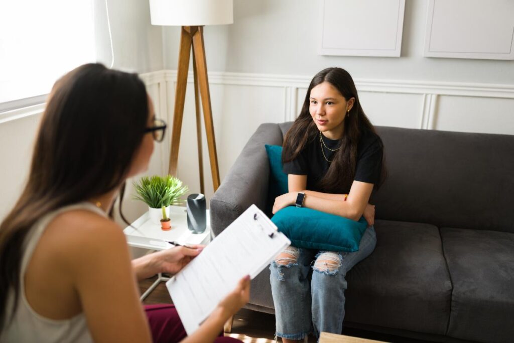 female therapist discussing the importance of therapy for teens with an teenage girl