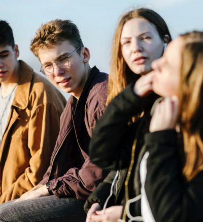 group of teenagers sitting outside